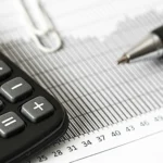 a photo of calculator and pen over a paper