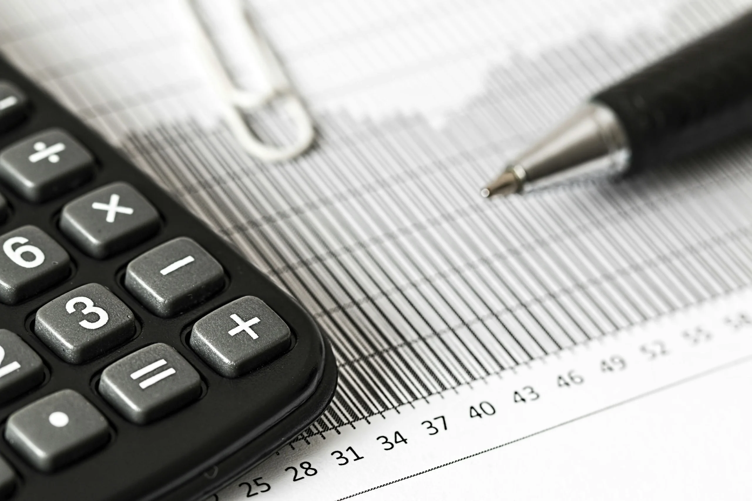 a photo of calculator and pen over a paper